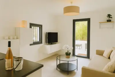 a white living room with a couch and a table at Maison, Jardin, piscine parking près d'Aix Centre in Venelles