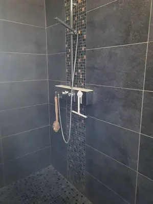 a bathroom with a shower with a tile wall at Coin de paradis en Provence in Sault-de-Vaucluse