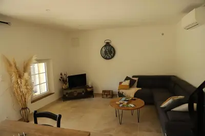 a living room with a couch and a clock on the wall at Duplex de charme au coeur de la Provence. in Pertuis
