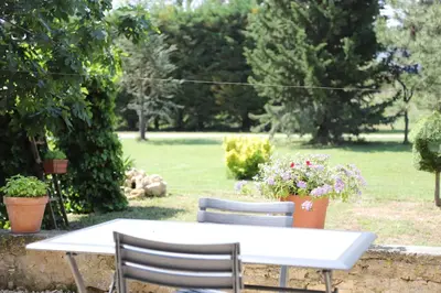 a white table and chairs with flowers in a yard at Duplex de charme au coeur de la Provence. in Pertuis
