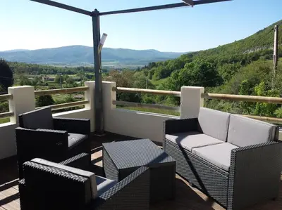 a balcony with chairs and tables and a view of mountains at Location provence ventoux sault in Sault-de-Vaucluse