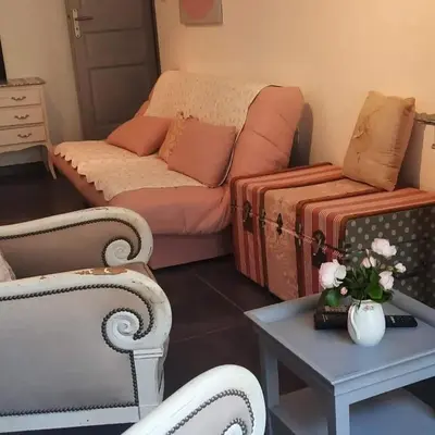 a living room with a couch and a table at Gite Au fond du jardin in Saint-Saturnin-lès-Avignon