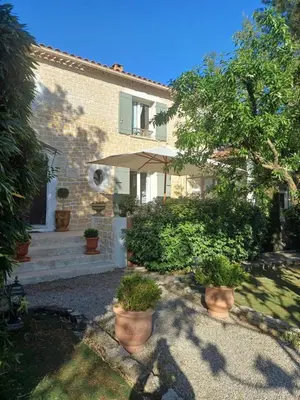 a house with an umbrella and some plants at Gite Au fond du jardin in Saint-Saturnin-lès-Avignon