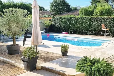 a swimming pool with an umbrella and a pool at Villa tout confort, piscine - Au pied du VENTOUX in Saint-Didier