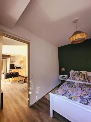 a bedroom with a bed with a green wall at Bienvenue à L'ÉCRIN avec piscine privée in LʼIsle-sur-la-Sorgue
