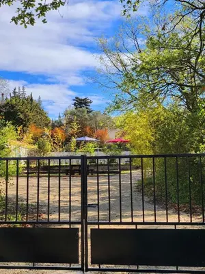 a gate with a bench in front of a park at Bienvenue à L'ÉCRIN avec piscine privée in LʼIsle-sur-la-Sorgue