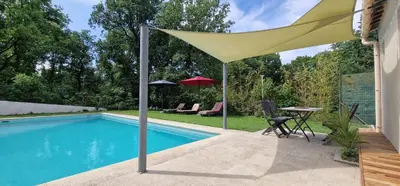 a yellow umbrella sitting next to a swimming pool at Bienvenue à L'ÉCRIN avec piscine privée in LʼIsle-sur-la-Sorgue