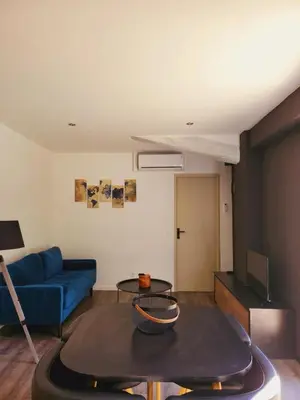 a living room with a blue couch and a table at Bienvenue à L'ÉCRIN avec piscine privée in LʼIsle-sur-la-Sorgue