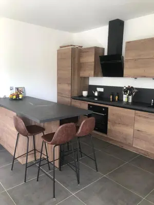 a kitchen with a black table and two stools at Appartement Aix en Provence vue Ste Victoire - BATIMENT B11 - 13090 AIX EN PROVENCE in Aix-en-Provence
