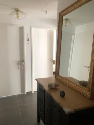 a bathroom with a mirror on a wooden dresser at Appartement Aix en Provence vue Ste Victoire - BATIMENT B11 - 13090 AIX EN PROVENCE in Aix-en-Provence