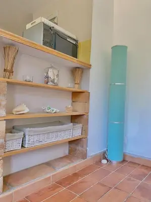 a room with wooden shelves and a blue heater at Maisonnette à la campagne. Idéal Télétravail in Éguilles