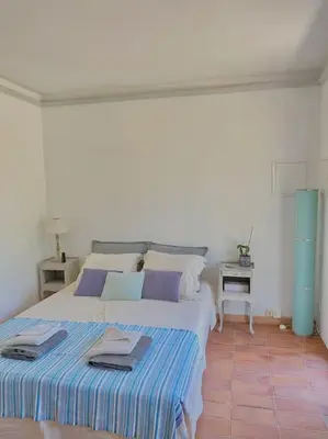 a bedroom with a large bed with towels on it at Maisonnette à la campagne. Idéal Télétravail in Éguilles