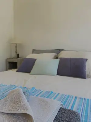 a bed with blue and white sheets and pillows at Maisonnette à la campagne. Idéal Télétravail in Éguilles