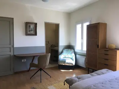 a bedroom with a bed and a desk and a chair at Hôtel Restaurant L’Observatoire in Saint-Michel-lʼObservatoire