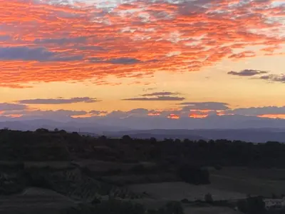 a sunset view of the mountains and forests at Hôtel Restaurant L’Observatoire in Saint-Michel-lʼObservatoire
