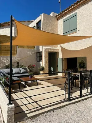 a patio with a table and a couch and a wooden table at La Ribasse en Provence in Venelles
