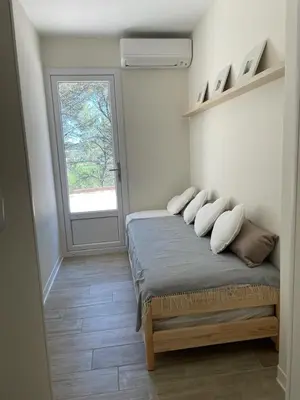 a bedroom with a bed with pillows and a window at La Ribasse en Provence in Venelles