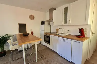 a kitchen with white cabinets and a wooden table at La calade in Vedène