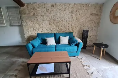 a blue couch in a living room with a table at La calade in Vedène