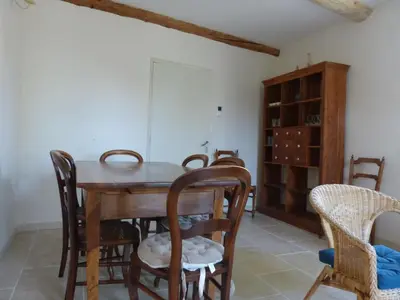 a dining room with a wooden table and chairs at Gite du domaine Saint-Marc, entre Ventoux et dentelles de Montmirail in Caromb
