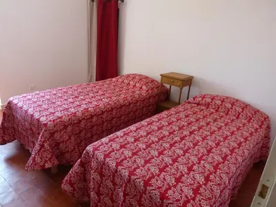 two beds in a small room with red blankets at Gite du domaine Saint-Marc, entre Ventoux et dentelles de Montmirail in Caromb