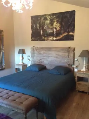 a bedroom with a bed and a painting of a zebra at La Maiz in Maubec