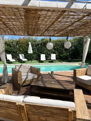 a patio with a pool and a table and chairs at La Maiz in Maubec