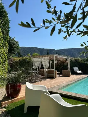 a backyard with a swimming pool and a table and chairs at La Maiz in Maubec