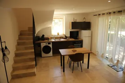 a kitchen with a table and a kitchen with a staircase at La Bastide au coeur de la Provence in Pertuis