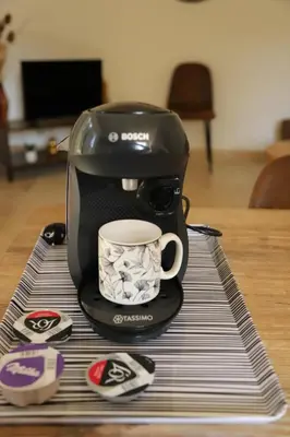 a coffee maker with a coffee cup on a table at La Bastide au coeur de la Provence in Pertuis