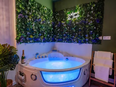 a bathroom with a tub with flowers on the wall at Sault Tropical - Idéal couple - Balnéo Led - Vue parc & montagne - Wifi - Stationnement gratuit - 5min à pied des bars, restaurants & commerces in Sault-de-Vaucluse