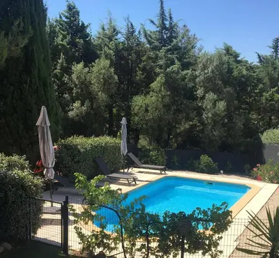 a swimming pool in a yard with an umbrella at Villa avec Piscine au coeur de la campagne provençale in Lançon-Provence