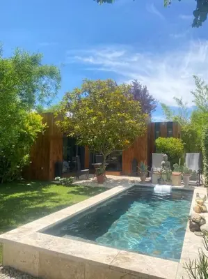 a swimming pool in a yard with trees and a fence at A lombre du magnolia in LʼIsle-sur-la-Sorgue
