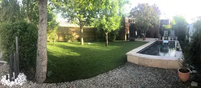 a backyard with a pond and trees and a yard at A lombre du magnolia in LʼIsle-sur-la-Sorgue