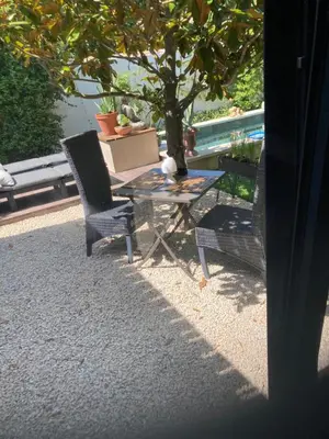 a table and two chairs sitting under a tree at A lombre du magnolia in LʼIsle-sur-la-Sorgue