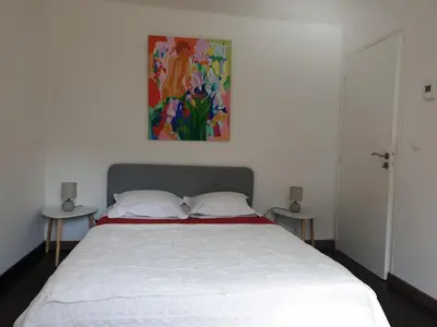 a bedroom with a bed with a painting on the wall at Maison calme et verdure in Saint-Cannat