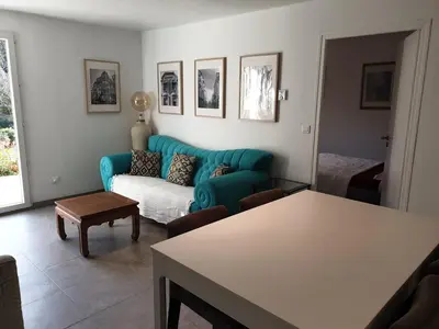 a living room with a blue couch and a table at Maison calme et verdure in Saint-Cannat