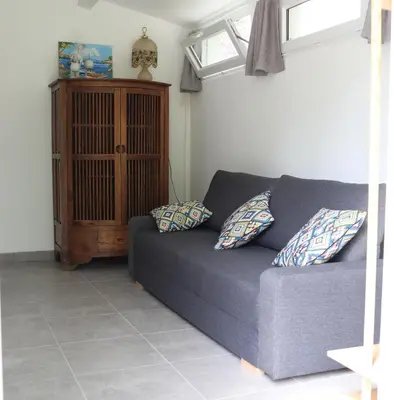 a couch in a living room with two pillows on it at Maison calme et verdure in Saint-Cannat