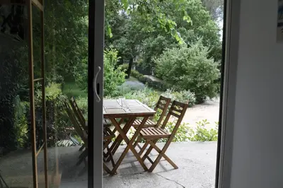 a wooden table and two chairs on a patio at Maison calme et verdure in Saint-Cannat