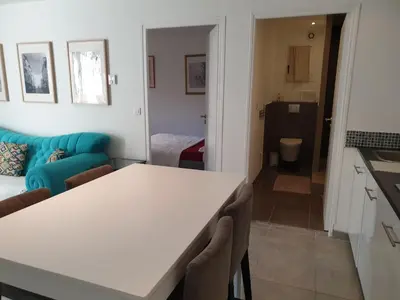 a kitchen and a living room with a table and a couch at Maison calme et verdure in Saint-Cannat