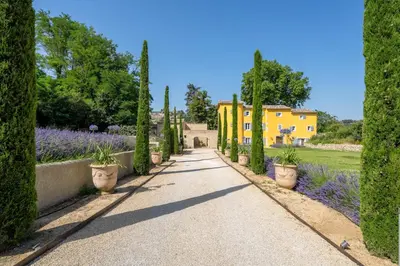 a stone house with a garden in front of it at Le Domaine du Fortin in Ménerbes