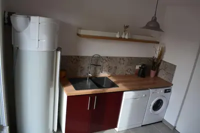 a kitchen with a sink and a refrigerator at Le mas de la joëlette in Vedène