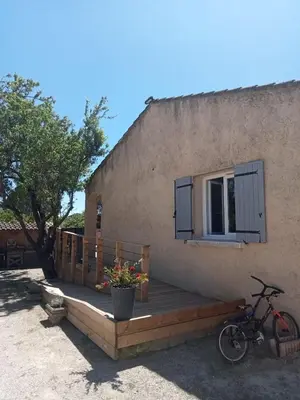 a bike parked next to a building with a wooden deck at Le mas de la joëlette in Vedène