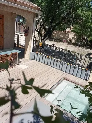 a wooden deck with a bench and a fence at Le mas de la joëlette in Vedène