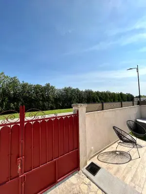a red fence with a table and a chair on a patio at Maison de charme avec Jacuzzi in Mollégès