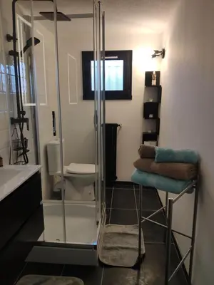 a bathroom with a glass shower with a stack of towels at La Tourelle Suite Cosy entre vignoble aixois et Luberon in Le Puy-Sainte-Réparade