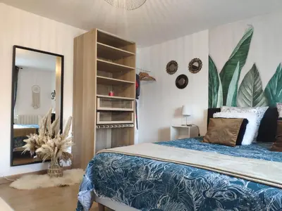 a bedroom with a bed and a large mirror at La Tourelle Suite Cosy entre vignoble aixois et Luberon in Le Puy-Sainte-Réparade