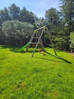 a swing set in a field of green grass at Gîte élégant au calme in Mazan