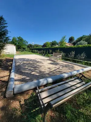 a bench sitting in the grass next to a park at Gîte élégant au calme in Mazan