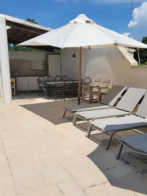 a group of chairs and an umbrella on a patio at Gîte élégant au calme in Mazan